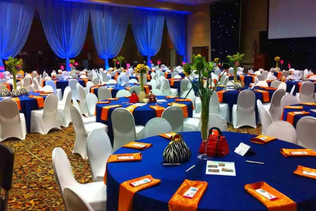 Grand corporate event with decorative drapes and dining tables