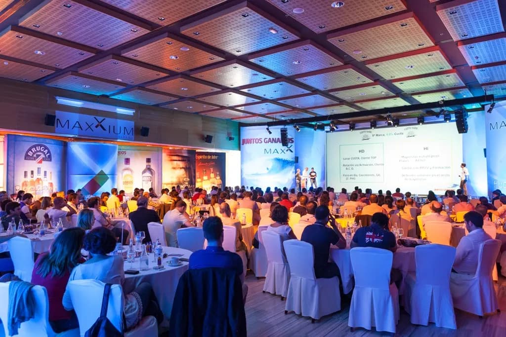 Business presentation event with MAXXIUM branding and seated guests